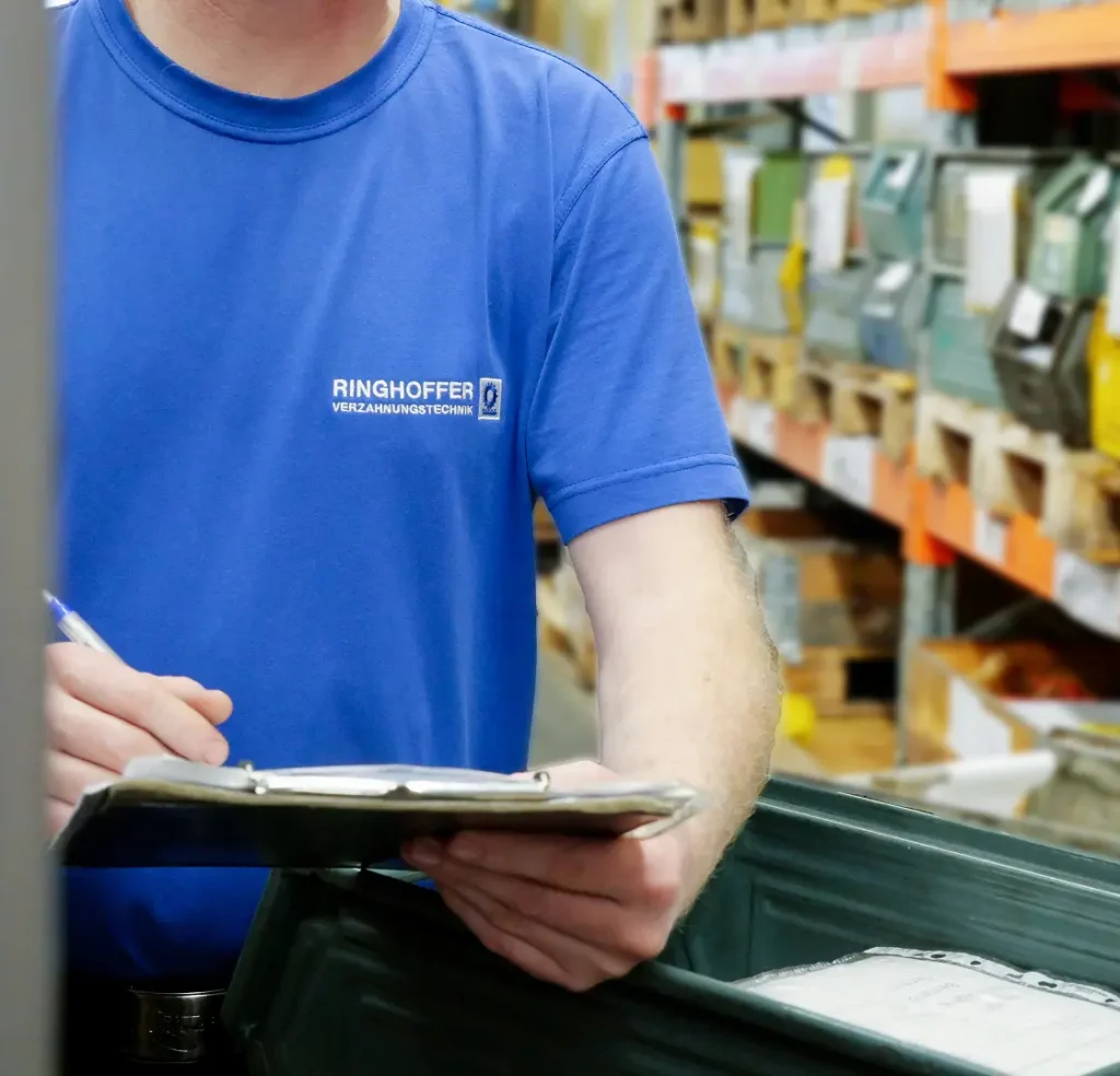 A Ringhoffer employee checks inventory in the warehouse using a clipboard