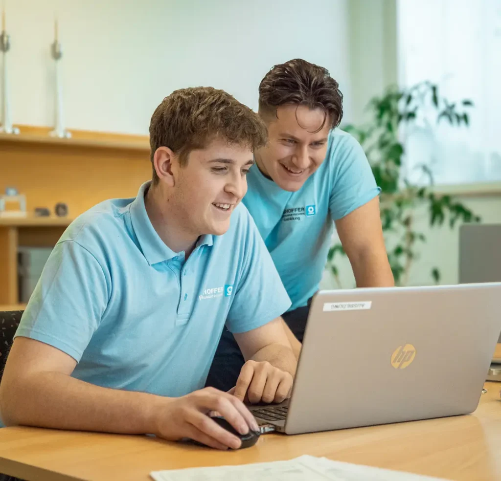 Zwei Ringhoffer-Auszubildende arbeiten gemeinsam am Laptop im Schulungsraum