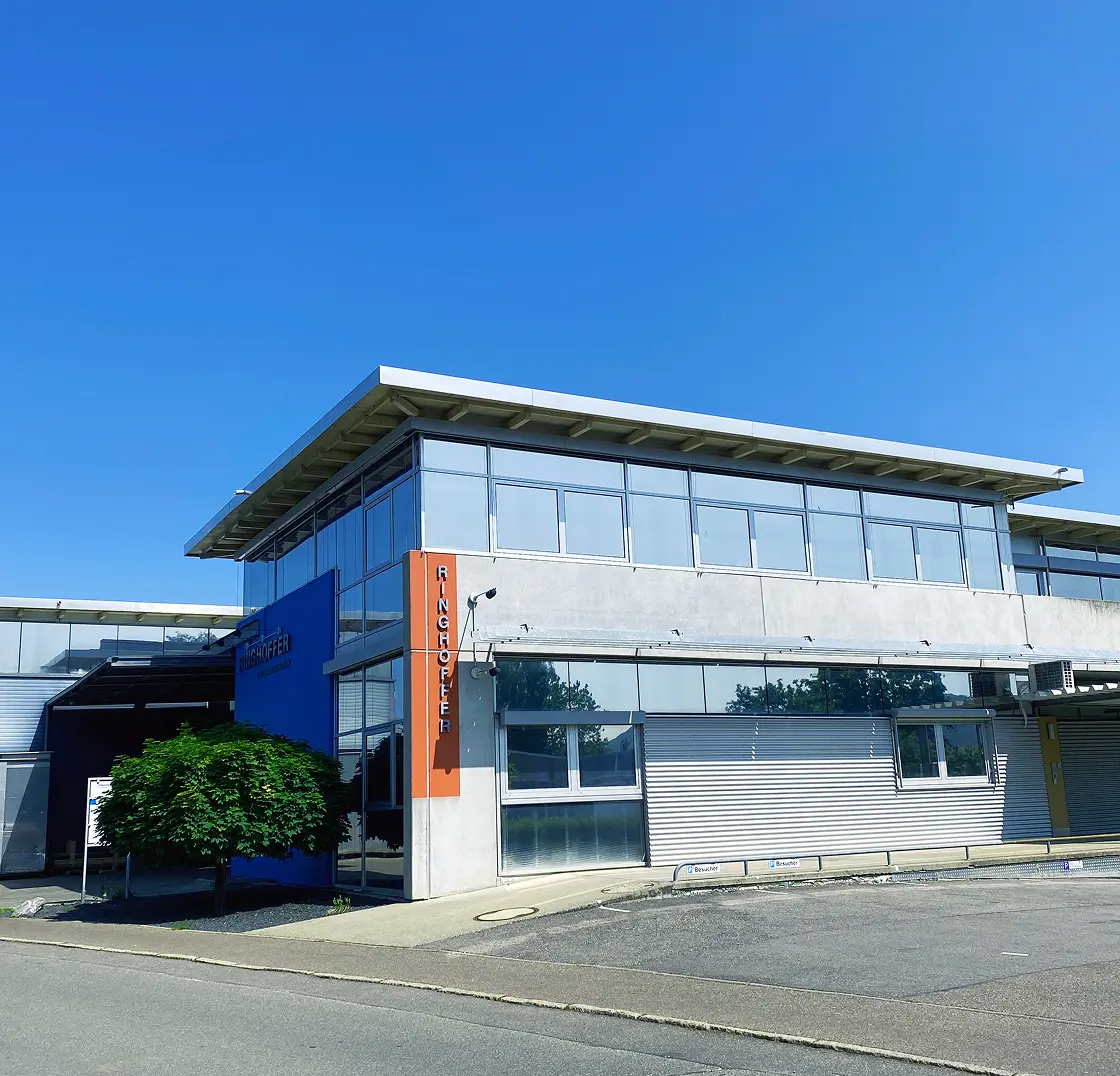Ringhoffer company building with blue facade, glass front, and orange company sign