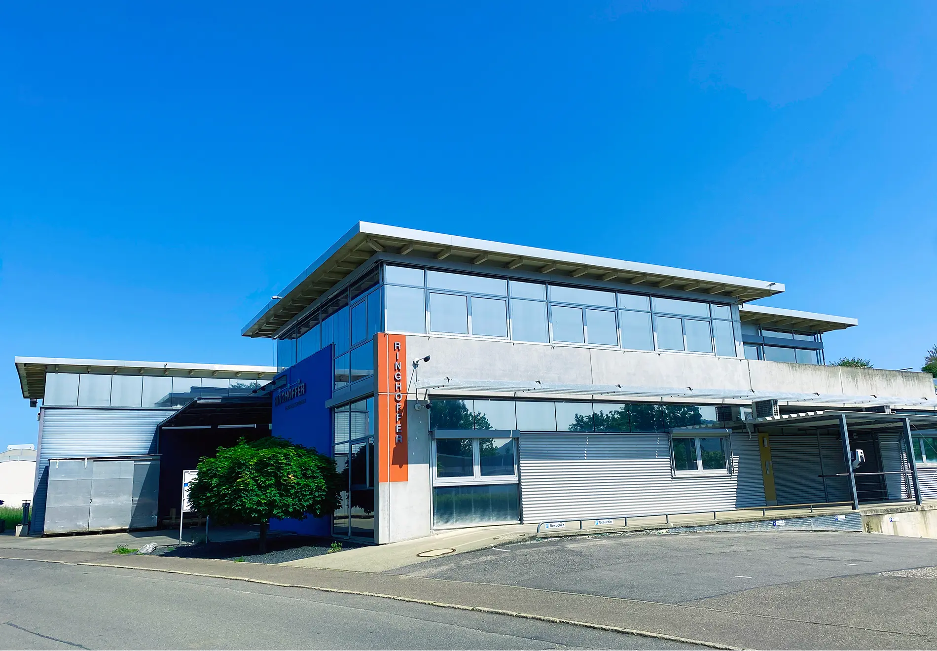 Ringhoffer company building with blue facade, glass front, and orange company sign