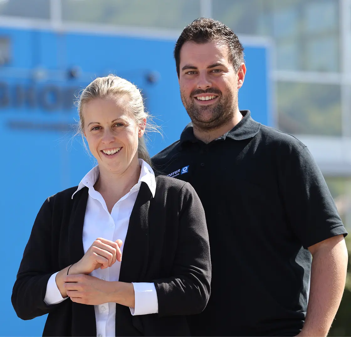 Romina Doster and Daniel Hofmann smile in front of the Ringhoffer company building
